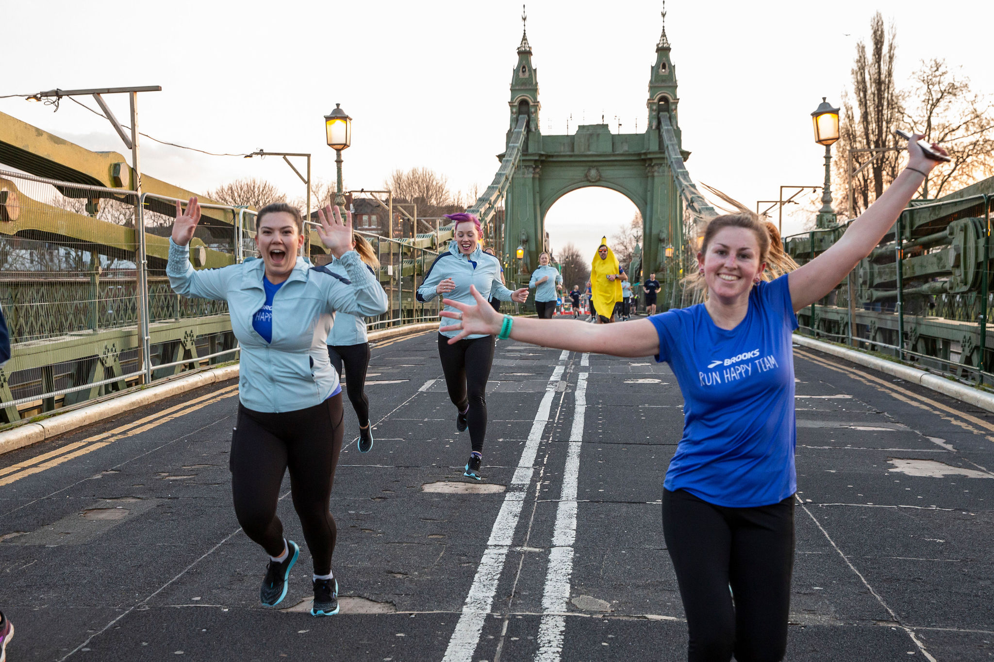 People running over a bridge celebrating